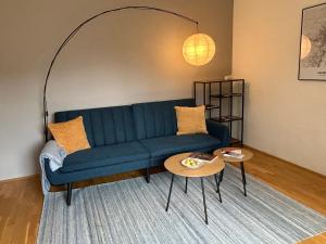 a living room with a blue couch and a table at Apartment Wien West in Vienna