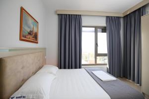 a bedroom with a large bed and a window at Diamond Hill Resort & SPA in Vlorë