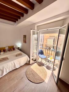 1 dormitorio con 1 cama, 1 silla y balcón en GATU PREMIUM Villa Flamenca, en Cádiz