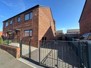 a fence in front of a brick building at 3 Bedrooms House in Manchester in Manchester
