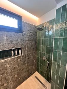 uma casa de banho com um chuveiro com azulejos verdes em Cora May Central Villa with private pool 200m to the beach em Faliraki