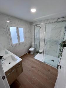 y baño con ducha, aseo y lavamanos. en GATU PREMIUM Villa Flamenca, en Cádiz