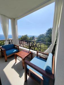 a balcony with chairs and tables and a view of the ocean at L & L Apartmani in Bol