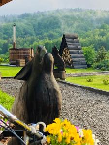 a statue of two birds sitting on a bike at Wilcza Chata in Polańczyk