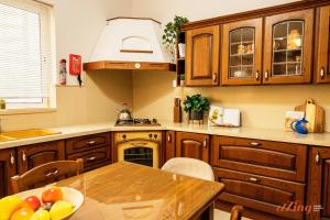 a kitchen with wooden cabinets and a table with a bowl of fruit at Live like a rockstar in this luxury home in Siġġiewi