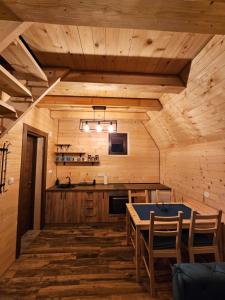 ein Esszimmer mit einem Tisch und einer Küche in der Unterkunft Oaza Jela in Mitrovac