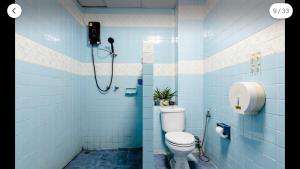 a blue tiled bathroom with a toilet and a shower at Flourish Apartments Sukhumvit 39 in Bangkok +37 photos
