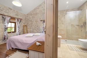a bedroom with a bed and a tub and a sink at Stone house Dijana Istria Sveti Lovrec in Sveti Lovreč Pazenatički +43 photos