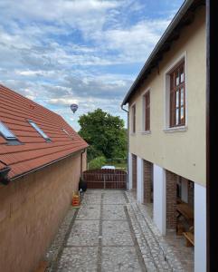un callejón entre dos edificios con un globo de aire caliente en el cielo en Vinařství Zatloukal Na kině en Pavlov