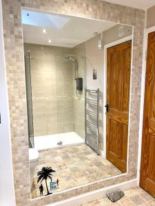 y baño con ducha, aseo y espejo. en Bear Cottage, Tyn Y Cwm en Eglwys-fach