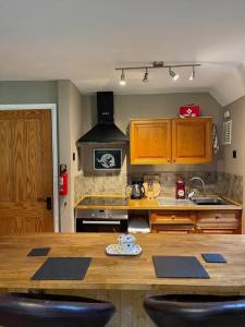 cocina con encimera de madera y fogones en Bear Cottage, Tyn Y Cwm en Eglwys-fach
