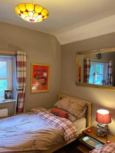 1 dormitorio con cama, espejo y mesa en Bear Cottage, Tyn Y Cwm en Eglwys-fach