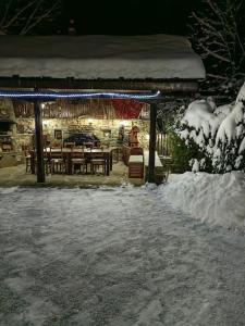 un pabellón con mesa y sillas en la nieve en Къща за гости КИМ en Apriltsi