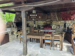 a dining room with a wooden table and chairs at Къща за гости КИМ in Apriltsi