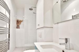 une salle de bain blanche avec un lavabo et des toilettes dans l'établissement Appartement Quartier Tour Eiffel Free Netflix, à Paris