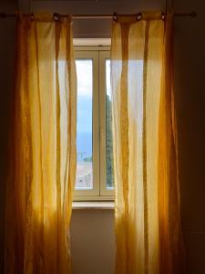 a window with orange and white curtains in a room at Innpiero in Taormina