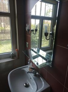 La salle de bains est pourvue d'un lavabo et d'un miroir. dans l'établissement Fantastyczny dom w lesie, à Długosiodło