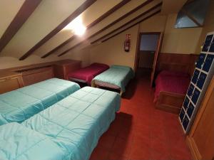 a room with three beds in a room at Albergue de Nuestra Señora Carrasquedo in Grañón