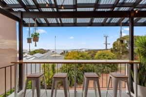 a balcony with a table and four stools at Valley View Home - 3 Bdrms, Bay Views, Woodfired Pizza Oven, Firepit in Port Lincoln