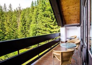a balcony with chairs and tables and a view of trees at Hotel SKI in Belá
