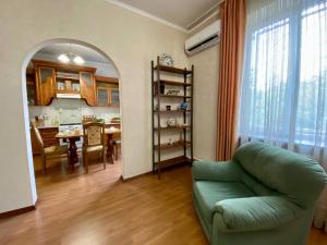 a living room with a green couch and a dining room at Guest House Botanika in Bishkek