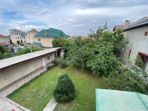 - une vue sur la cour avec des arbres et des maisons dans l'établissement Guest House Botanika, à Bishkek