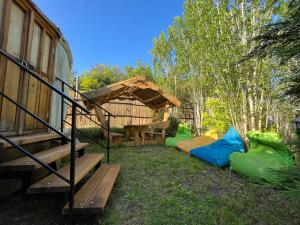 a group of tents in the grass next to a cabin at Mágustanya Jurtaszállás in Paloznak