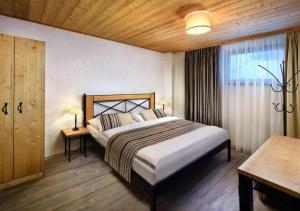 - une chambre avec un grand lit et une fenêtre dans l'établissement Chalets Jasná Collection - Apartments, à Demänovská Dolina