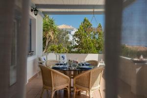 a table and chairs on a balcony with a view at Beachfront villa Coco in Karafotaíika