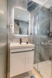 a bathroom with a white sink and a shower at Perfect Living in Rhodes Town