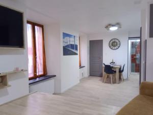 a living room with a television and a table with chairs at un trésor a découvrir - escapade millavoise in Millau