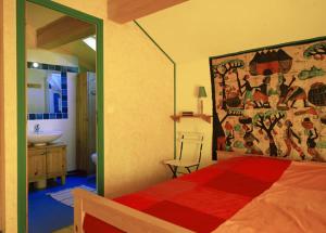 a bedroom with a bed and a bathroom with a sink at Le Mas Franc in Enveitg