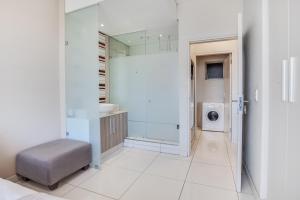 a bathroom with a sink and a washing machine at Urban Oasis Apartments at Tyrwhitt in Johannesburg