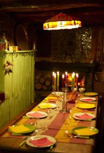 - une longue table en bois avec des assiettes et des bougies dans l'établissement Le Mas Franc, à Enveitg