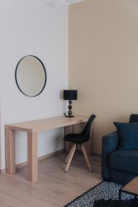 - un bureau avec une chaise et un miroir mural dans l'établissement Vesiroosi Apartments - Apartment 2, à Pärnu