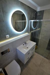 bagno con lavandino bianco e specchio di Domki Luan Village a Władysławowo