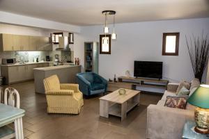 a living room with a couch and chairs and a kitchen at Sweet Home near Patras in Patra