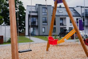 einen Spielplatz mit Schaukel in einem Park in der Unterkunft Vesiroosi Apartments - Apartment 2 in Pärnu