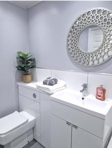 a white bathroom with a toilet and a mirror at Flat in Hamilton, South Lanarkshire in Hamilton