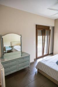 een slaapkamer met een bed en een spiegel op een dressoir bij Sweet Home near Patras in Patra