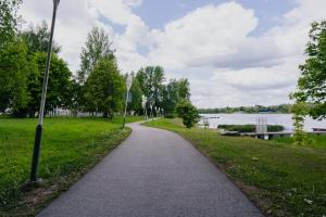 einen Weg durch einen Park neben einem See in der Unterkunft Vesiroosi Apartments - Apartment 2 in Pärnu