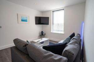 uma sala de estar com um sofá e uma televisão em Luxurious 1 Bedroom Central Apartment. Sleeps 4 em Blackpool