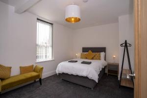 um quarto com uma cama e uma cadeira em Luxurious 1 Bedroom Central Apartment. Sleeps 4 em Blackpool