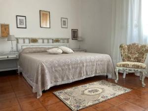 a bedroom with a bed and a chair at Casa Rosalina Sardinia Italy in Luogosanto