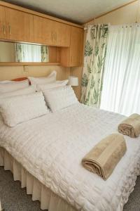 a large white bed in a room with a window at Treetops in Lamplugh