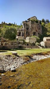 a group of houses on a hill next to the water at Mobile home 6 places camping 5 Vacances Gorges de lArdeche in Lagorce