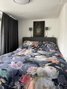 - une chambre dotée d'un lit avec un couvre-lit floral dans l'établissement Appartement in Centrum Alkmaar, à Alkmaar