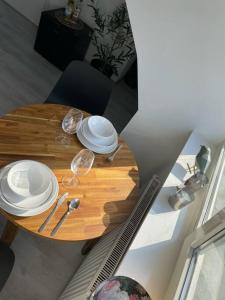 - une table en bois avec des assiettes et des verres à vin dans l'établissement Appartement in Centrum Alkmaar, à Alkmaar
