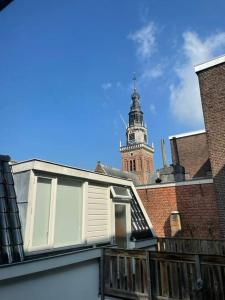 un bâtiment avec une tour d'horloge en arrière-plan dans l'établissement Appartement in Centrum Alkmaar, à Alkmaar