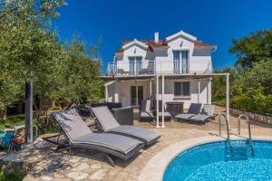 a villa with a swimming pool and a house at Holiday Home OLIVE GARDEN in Brzac